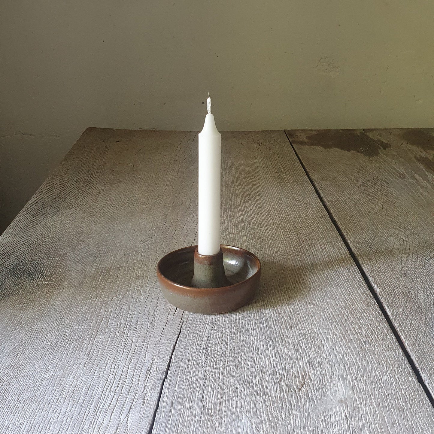 Zu sehen ist ein Kerzenständer in grün/braun Kastanie