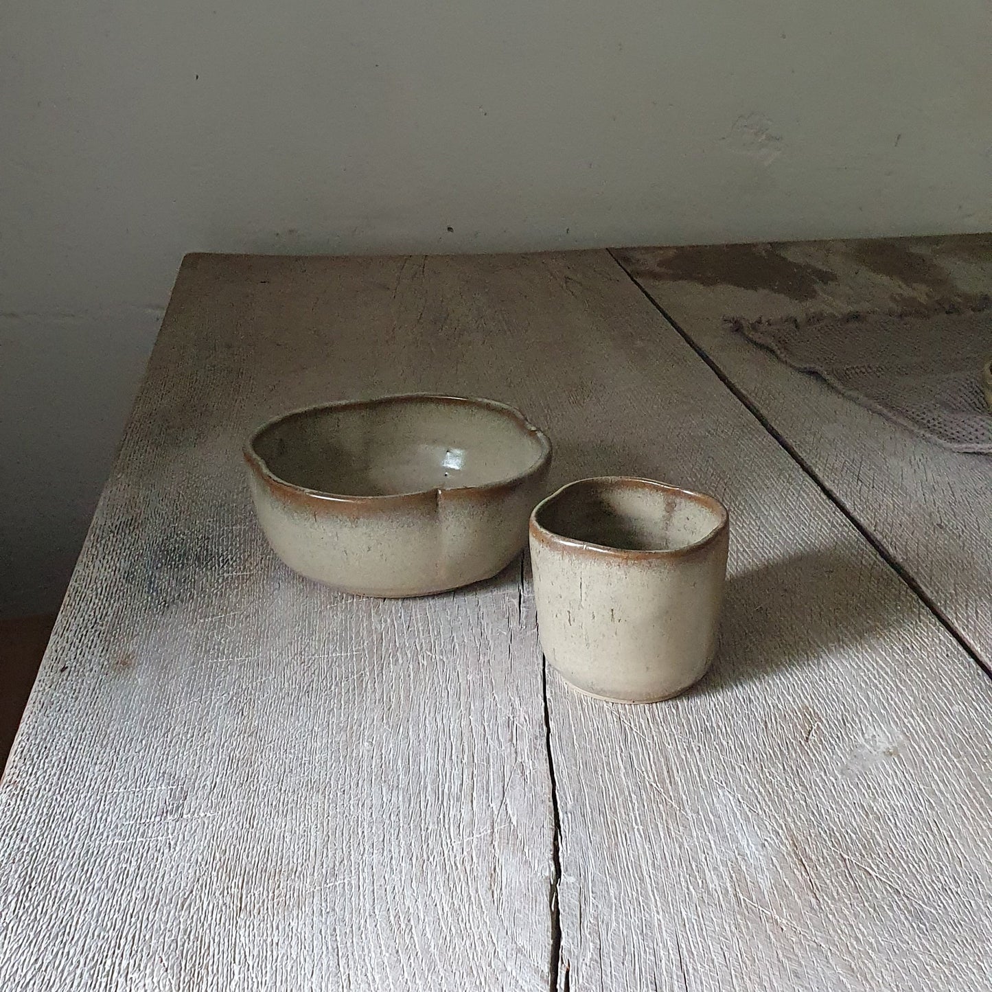 Zu sehen ist ein Keramik-Tisch-Set, Becher und Müsli-Schale in der Farbe Beige/Sandsturm.