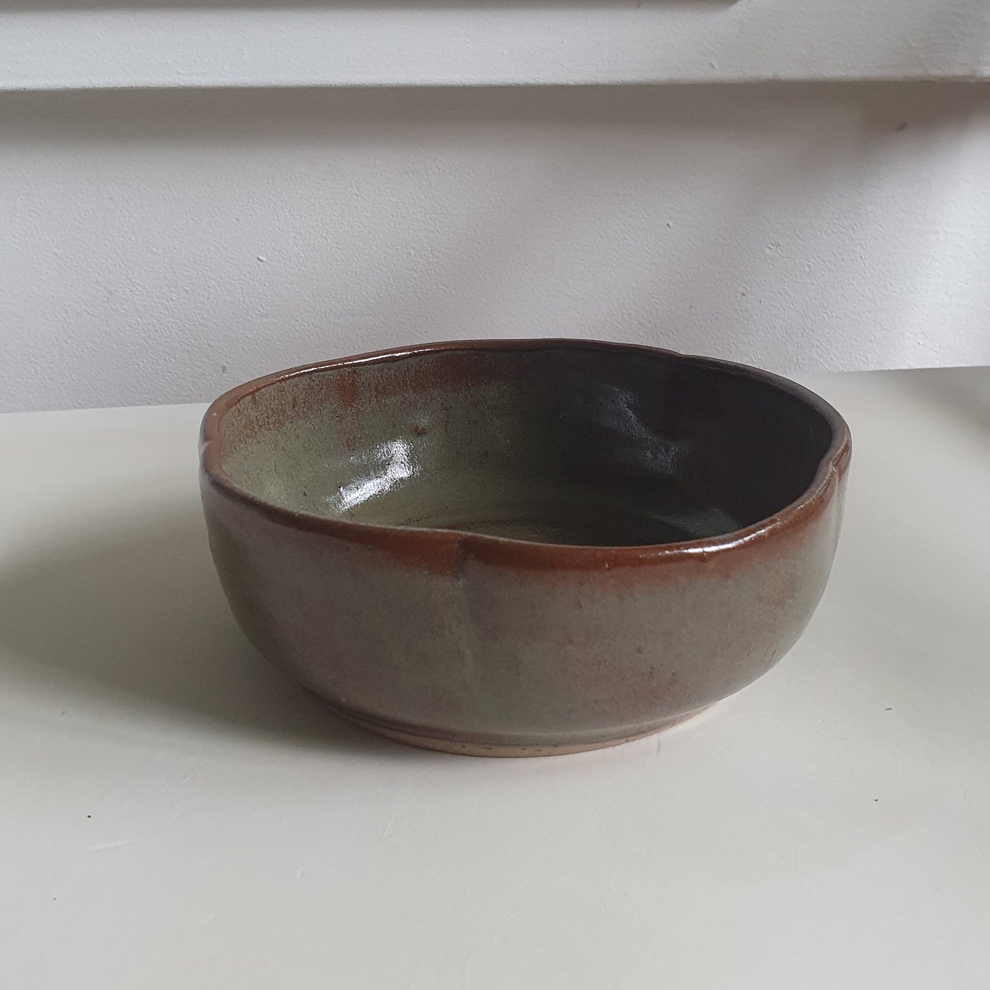 Zu sehen ist eine handgemachte Keramik Müsli-Schale in der Farbe Grün/Braun.