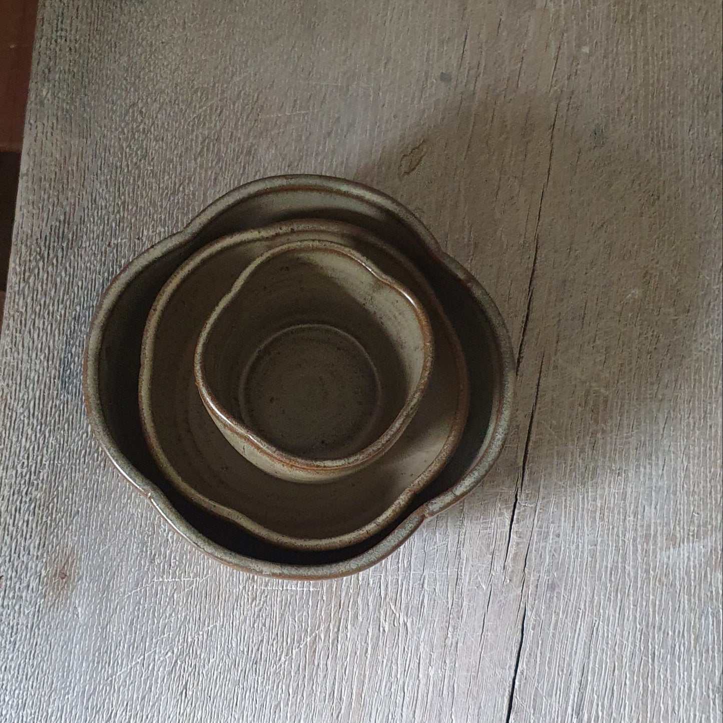 Zu sehen ist ein handgemachtes Keramiktisch-Set in der Farbe Grün/Braun von oben.