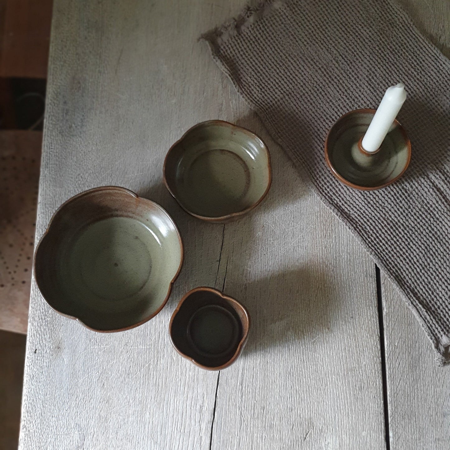 Zu sehen ist ein handgemachtes Keramiktisch-Set in der Farbe Grün/Braun von oben.