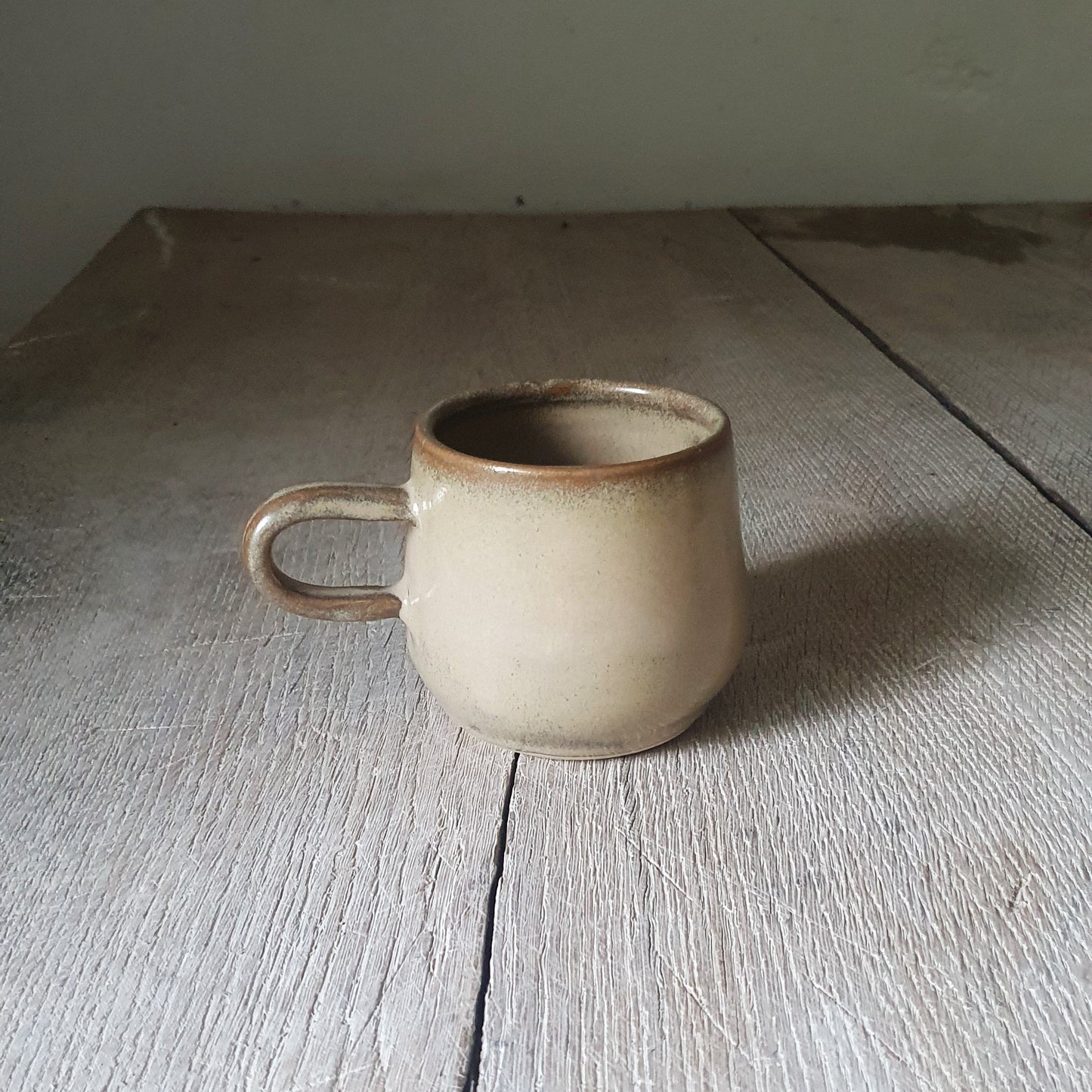 Zu sehen ist eine handgemachte Keramik-Tasse in der Farbe Beige/Sandsturm