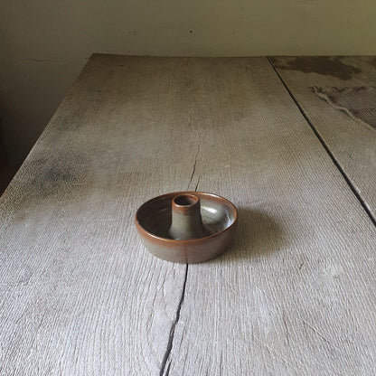 Zu sehen ist ein Kerzenständer in Grün/Braun Kastanie