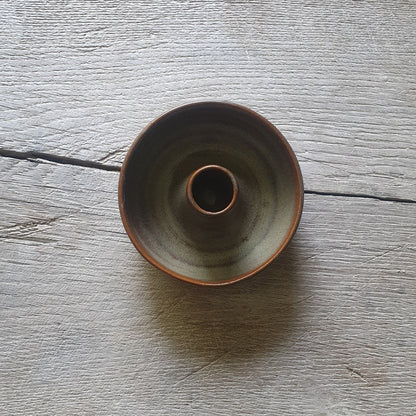 Zu sehen ist ein Kerzenständer in Grün/Braun Kastanie