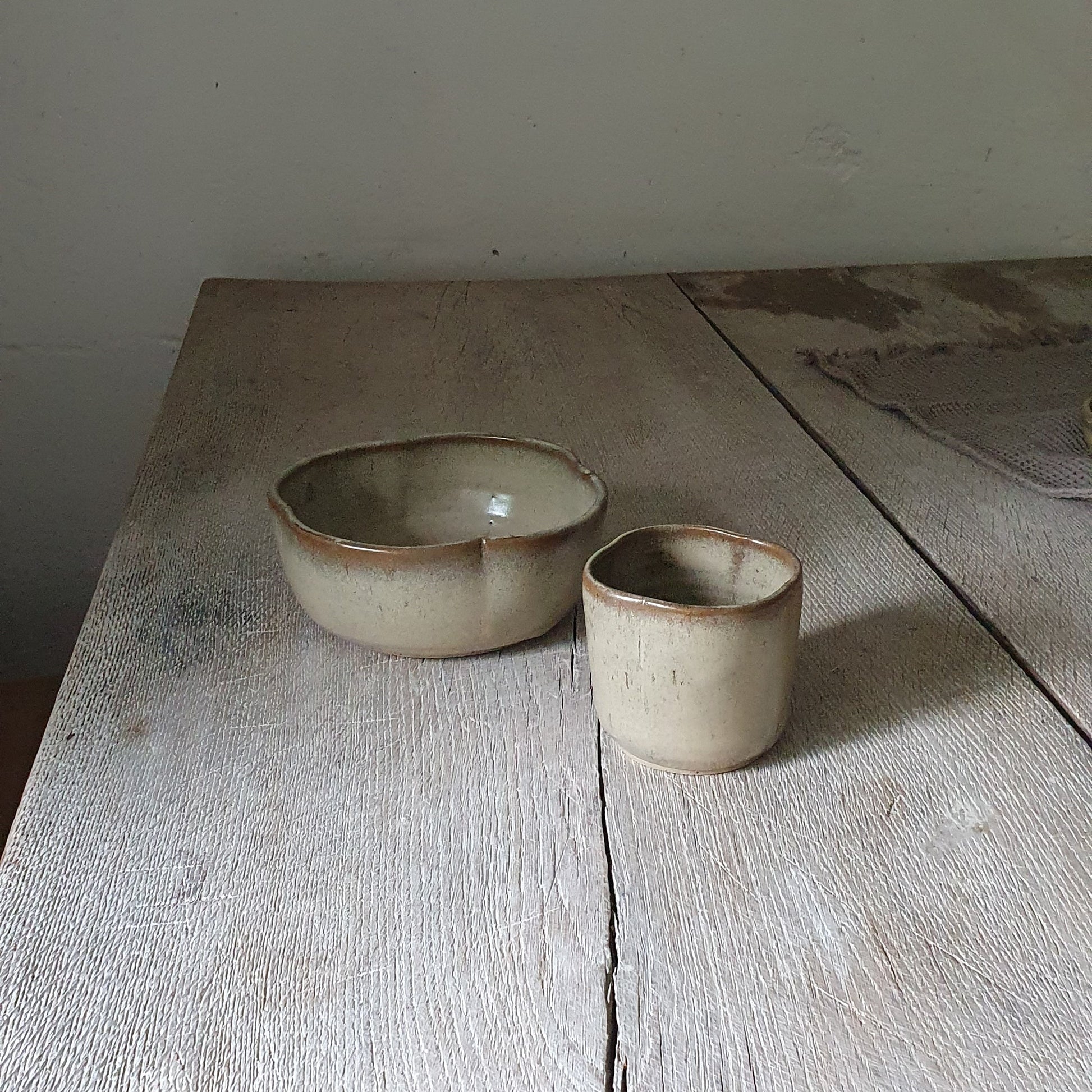 Zu sehen ist ein Keramik-Tisch-Set, Becher und Müsli-Schale in der Farbe Beige/Sandsturm.