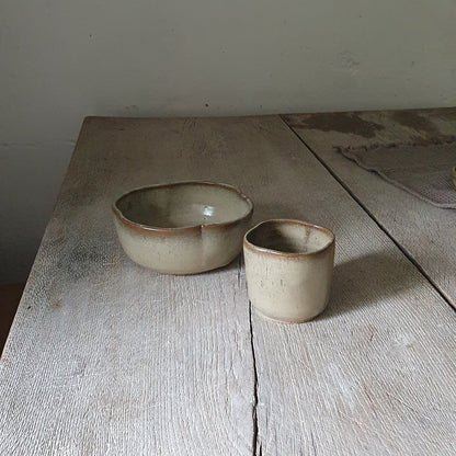 Zu sehen ist ein Keramik-Tisch-Set, Becher und Müsli-Schale in der Farbe Beige/Sandsturm.