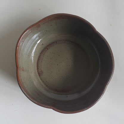 Zu sehen ist eine handgemachte Müslischale in der Farbe 
grün/braun Kastanie.
