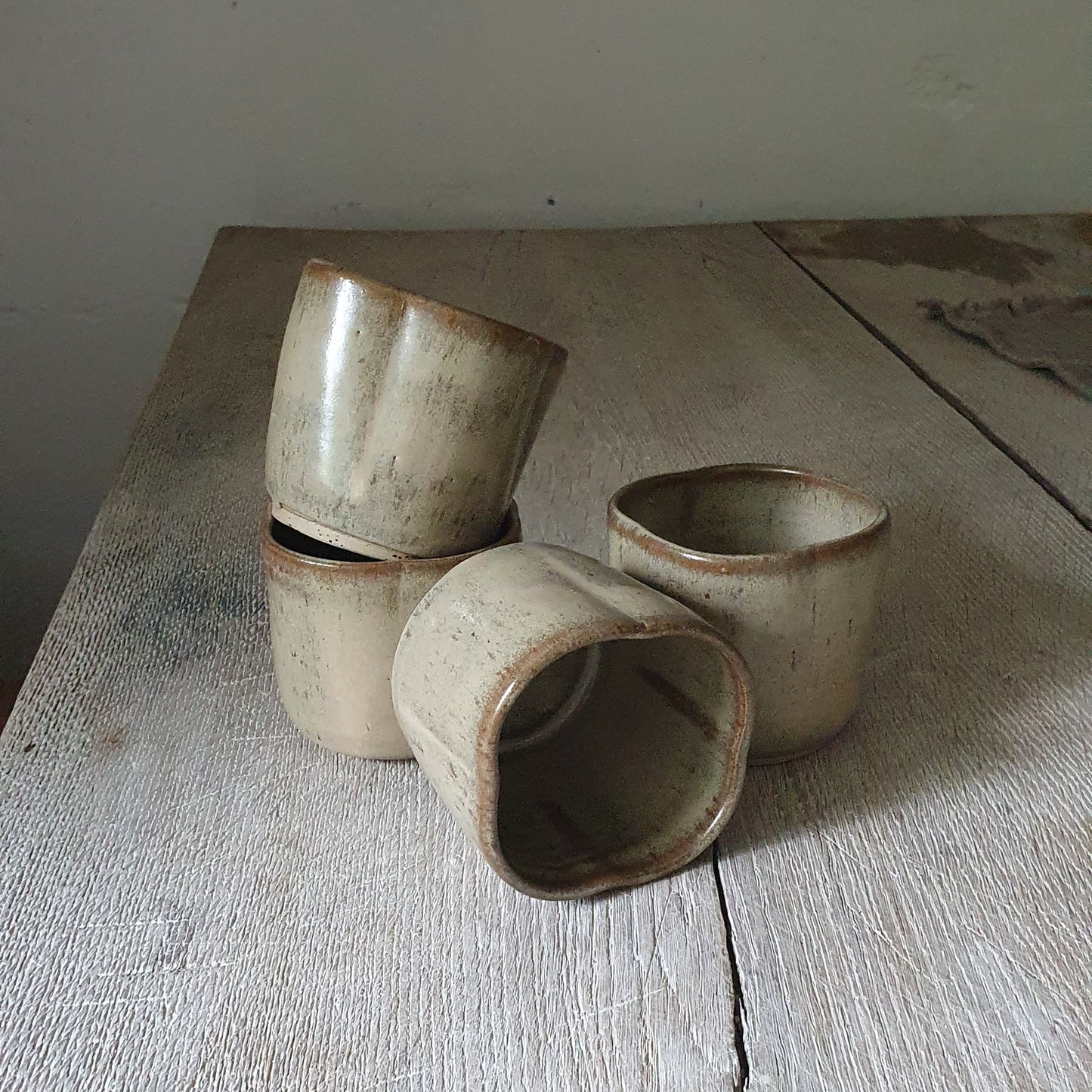 Zu sehen sind 4 handgemachter Keramik-Becher in der Farbe Beige
