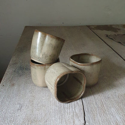 Zu sehen sind 4 handgemachter Keramik-Becher in der Farbe Beige

