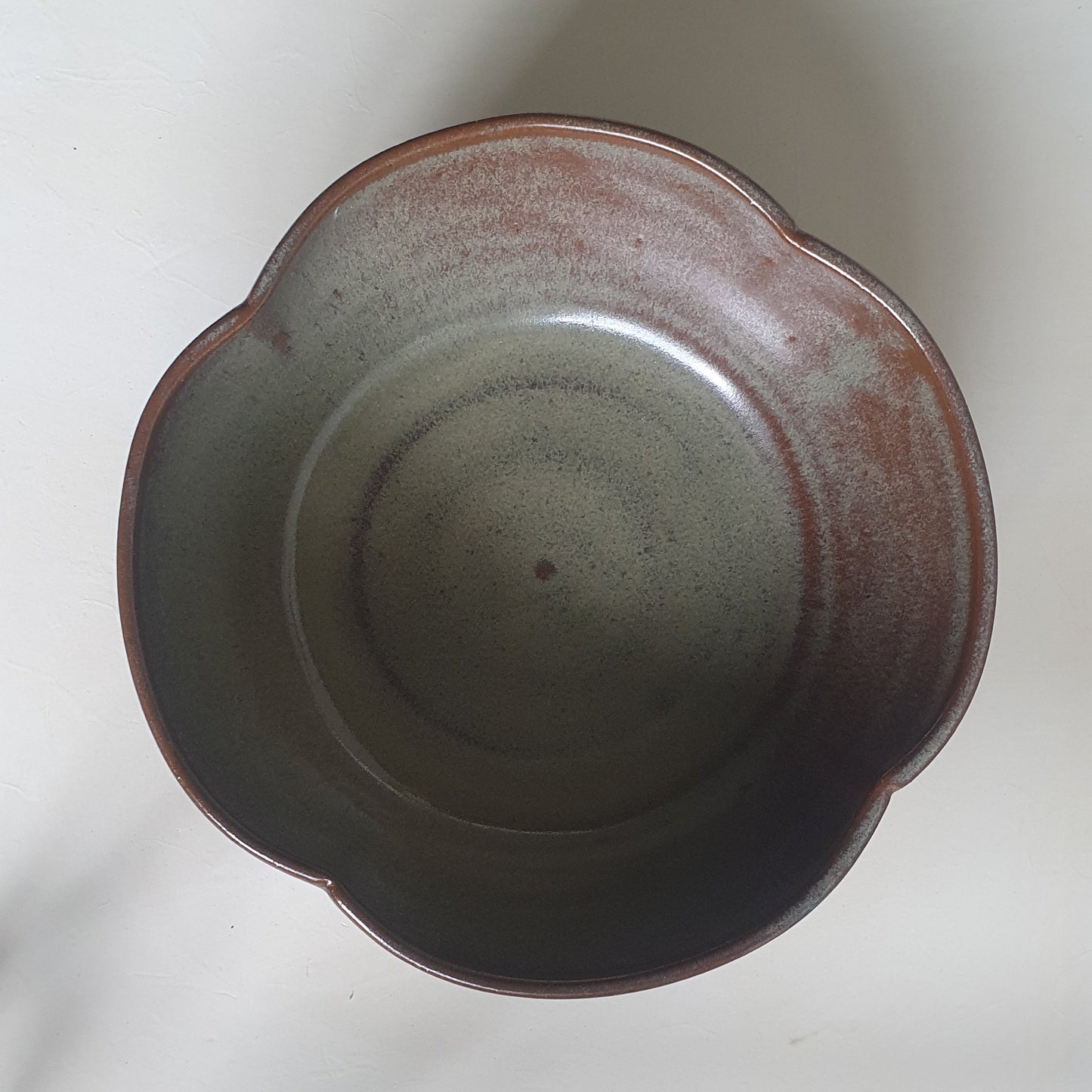 Zu sehen ist eine handgemachte Keramik Müsli-Schale in der Farbe Grün/Braun .