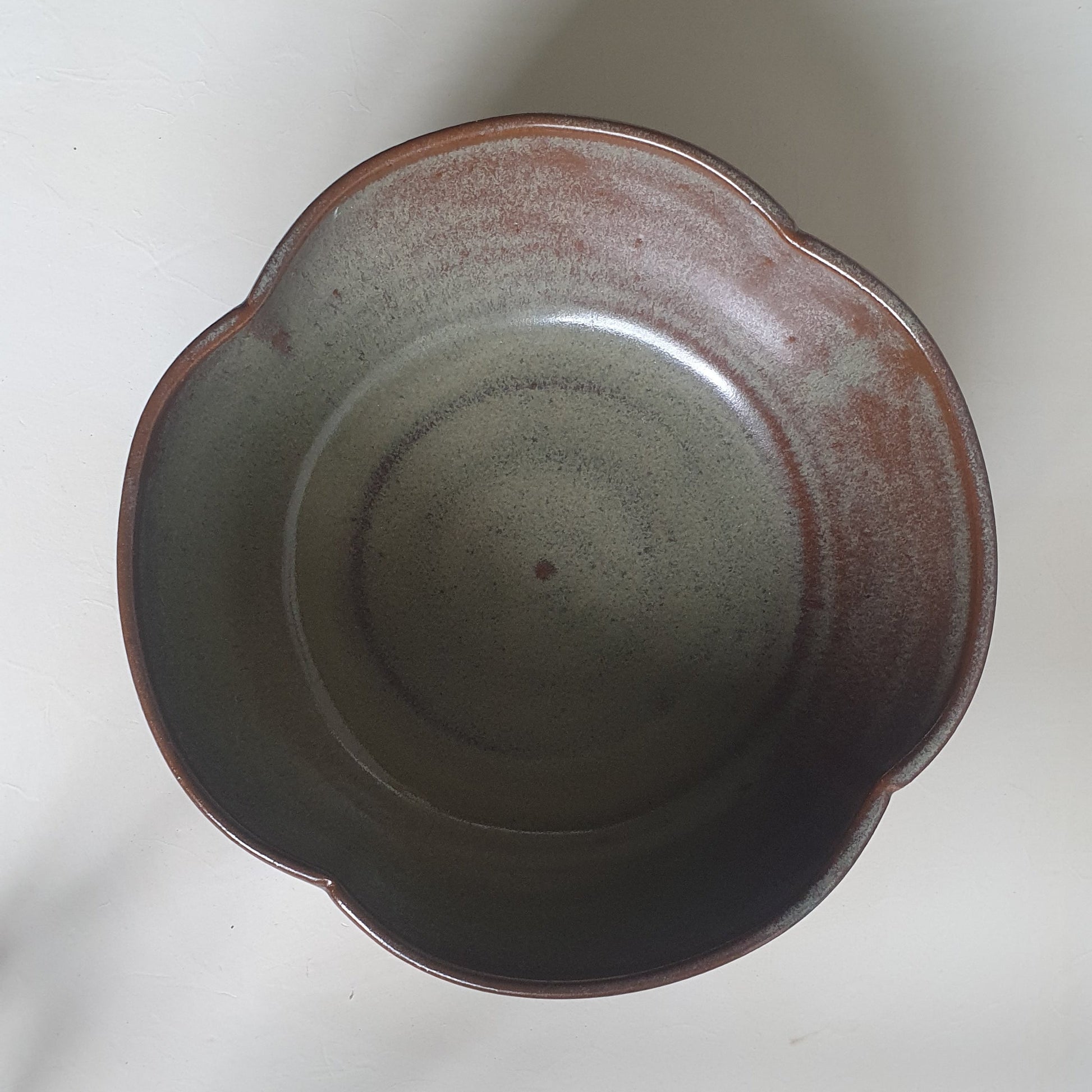 Zu sehen ist eine handgemachte Keramik Müsli-Schale in der Farbe Grün/Braun .