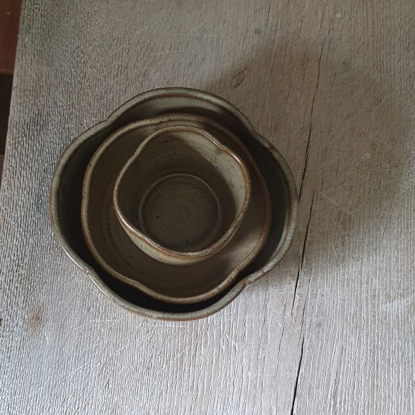 Zu sehen ist ein handgemachtes Keramiktisch-Set in der Farbe Grün/Braun von oben.
