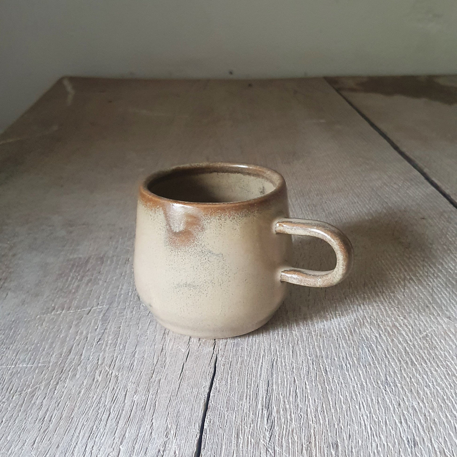 Zu sehen ist eine handgemachte Keramik-Tasse in der Farbe Beige/Sandsturm
